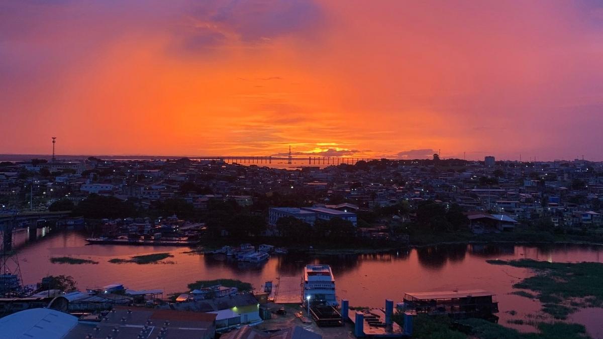 por do sol em tons vibrantes em manaus com ponte rio negro ao fundo foto reproducao